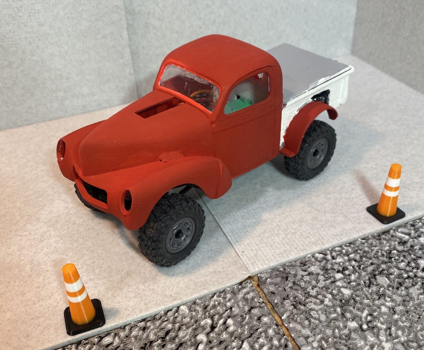 A 1940 Willys pickup model kit body on the crawler chassis, front three-quarter view between two miniature traffic cones.